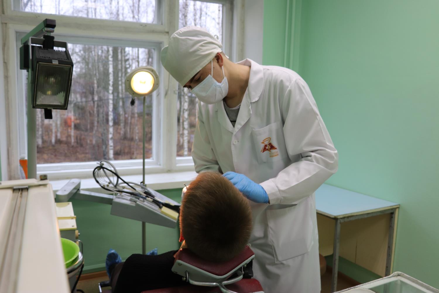 Молодой стоматолог ведет прием
